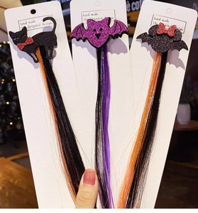Detailed view of Halloween hair clips with sparkly bats and colorful hair extensions