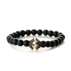 Elastic natural stone bracelet with matte black beads and bronze crown charms