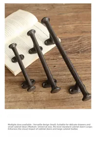 Macro view of three vintage cast iron door handles in various sizes on rustic wood surface