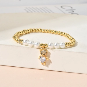 Beaded bracelet with gold beads, white pearls and a heart zircon teddy bear pendant