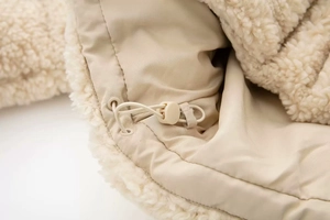Gros plan d'une veste en polaire beige avec cordon réglable et doublure interne