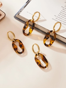 Detail view of vintage geometric leopard resin link earrings with golden metal loops