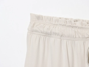 Detail of beige twill pants featuring an elastic waistband and fine stitching craftsmanship