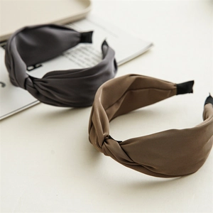 Close-up of matte silk fabric texture and twisted design on wide-brimmed headbands