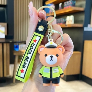 Porte-clés ours policier marron avec gilet jaune et dragonne en silicone assortie
