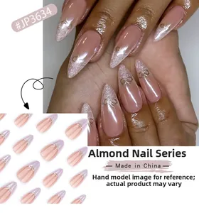 Détail de faux ongles en amande avec finition nacrée nue et nœuds dorés en relief