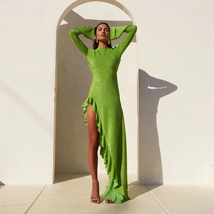 Détail de la robe en maille pailletée verte avec fente haute et ourlet à volants