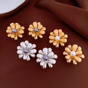 Detail of 18k gold plated flower earrings with pearls on dark vintage fabric