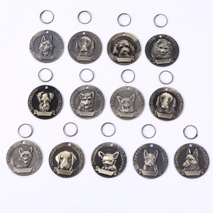 Macro detail of antique bronze dog ID tags featuring 3D embossed breed portraits
