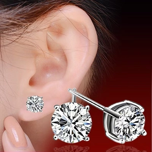 Close-up of classic round-cut diamond earrings in silver plating worn on earlobe