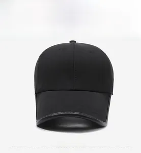 Detailed close-up of a black baseball cap with leather trim edges and twill fabric texture