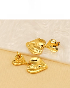 Détails de boucles d'oreilles double cœur en or 18K avec texture martelée sur pierre