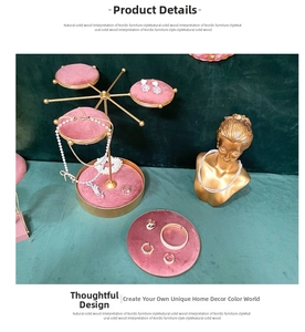 Detail of pink velvet trays on golden metal jewelry stand for rings and necklaces