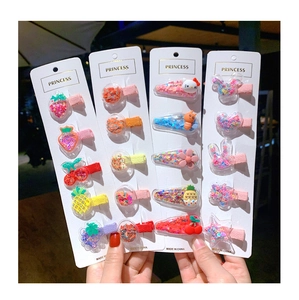 Detail of glitter-filled fruit and cartoon hair clips for girls with sequins