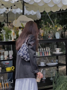 Detail of dark blue denim hobo bag featuring white leopard print on the shoulder