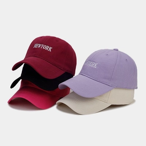 Pile di cappellini da baseball colorati con ricamo NEWYORK in vari colori trendy