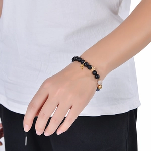Detail of obsidian beaded bracelet featuring golden Sagittarius and star charm pendants