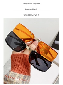 Detail of steampunk oval sunglasses in orange and dark grey with gold metal bridge