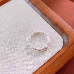Macro shot of silver brushed metal ring with vertical texture on a linen display tray