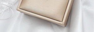 Detailed view of an elegant beige silk texture jewelry box for the teardrop necklace