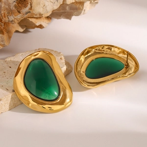 Vintage irregular gold earrings with deep green resin stone on a natural stone base