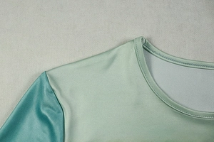 Detail shot of crew neck and shoulder stitching on mint green color-block dress