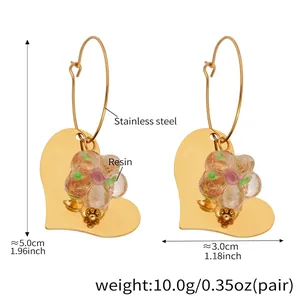 Détail de créoles coeur dorées 18k avec fleur en résine et informations de mesure