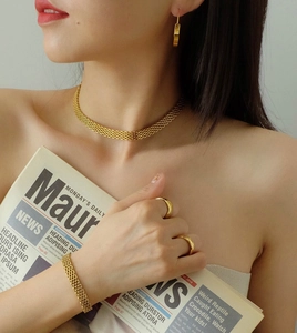 Dettaglio del set di gioielli in maglia dorata con collana bracciale e orecchini