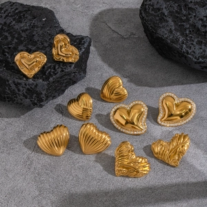 Elegant gold heart earrings with polished, textured, and rhinestone details on stone