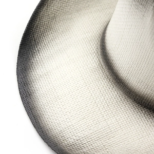 Macro detail of sun hat showing intricate ombre woven texture and fiber material