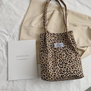 Detailed view of leopard print canvas tote bag on neutral lifestyle background
