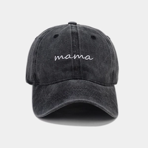 Detail of embroidered 'mama' text on washed cotton baseball cap with vintage texture