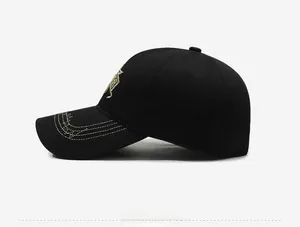 Detailed side profile of black cotton baseball cap with intricate gold star embroidery