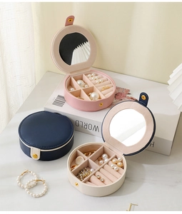 Vue détaillée de boîtes à bijoux rondes portables en rose, bleu marine et blanc avec miroir