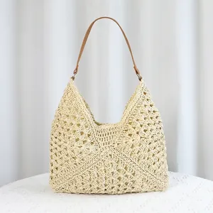 Minimalist straw tote bag with intricate openwork weave and brown leather strap