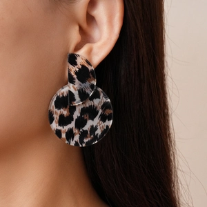 Close-up of model wearing leopard print acrylic circular drop earrings for a stylish look
