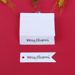 Dettaglio macro di etichette natalizie in carta con stampa Merry Christmas su rosso