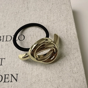 Minimalist gold knot elastic hair tie with a polished geometric Mobius twist design
