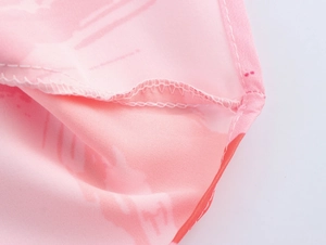 Detail of sewing craftsmanship and fabric texture on a pink floral summer maxi dress