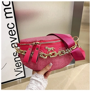 Detail of pink woven fanny pack featuring a gold unicorn ornament and chain decoration