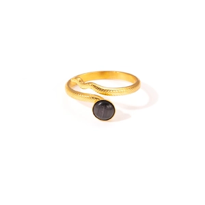 Macro detail of golden snake ring featuring scale texture and an inlaid black stone