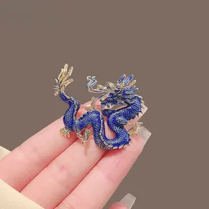 Detailed macro view of a dragon brooch with blue enamel and gold-plated metal accents