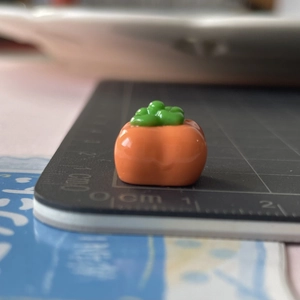 Vista dettagliata della scala di un mini ciondolo in resina da 1,5 cm per fermagli fai-da-te