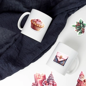 Pink Christmas art stickers on ceramic mugs with festive candle and cake designs