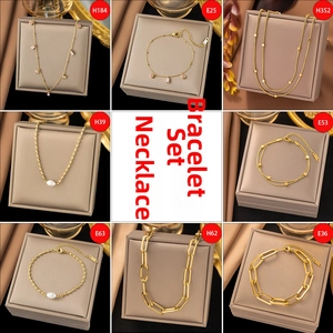 Detailed grid of gold necklaces and bracelets featuring pearls and pink zircon accents
