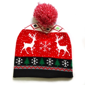 Detailed knit texture of a festive Christmas beanie with reindeer and snowflake patterns