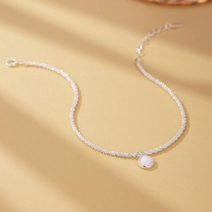 Macro shot of S925 silver chain with a round white opal pendant on soft background