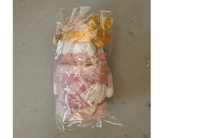 Detailed view of pink and gold Christmas plush toy with sequins in protective packaging