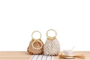 Detail of hand-woven mesh bag featuring solid wood handles and a removable cloth liner