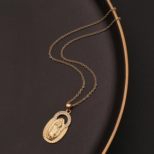 Collier pendentif Vierge Marie dorée avec cristaux sur un plateau noir élégant